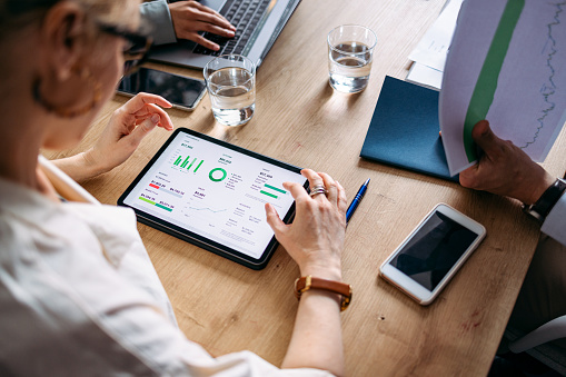 A team reviewing live analytics on a tablet at a meeting table